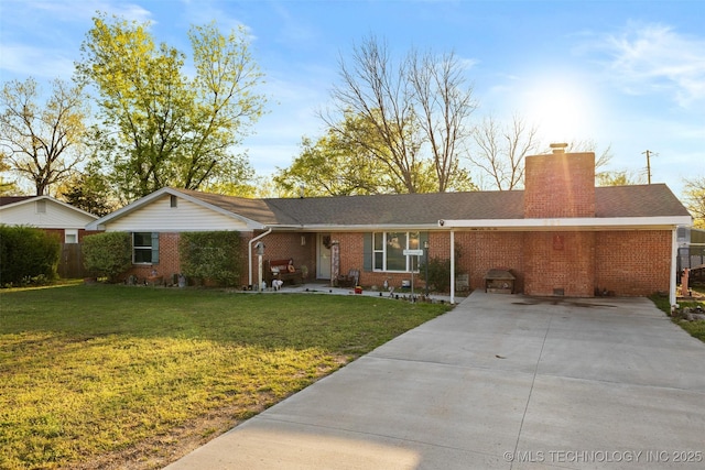 ranch-style home with brick siding, driveway, a chimney, and a front lawn
