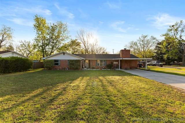 ranch-style house with a chimney, concrete driveway, brick siding, a front lawn, and an attached carport