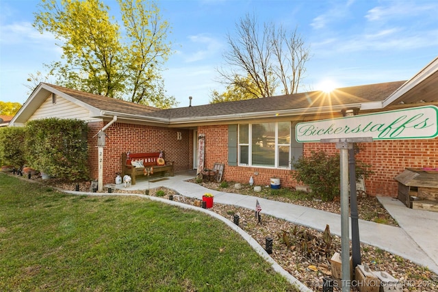 ranch-style house with brick siding and a front lawn