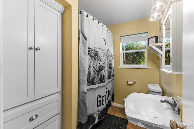 full bathroom with a sink and baseboards