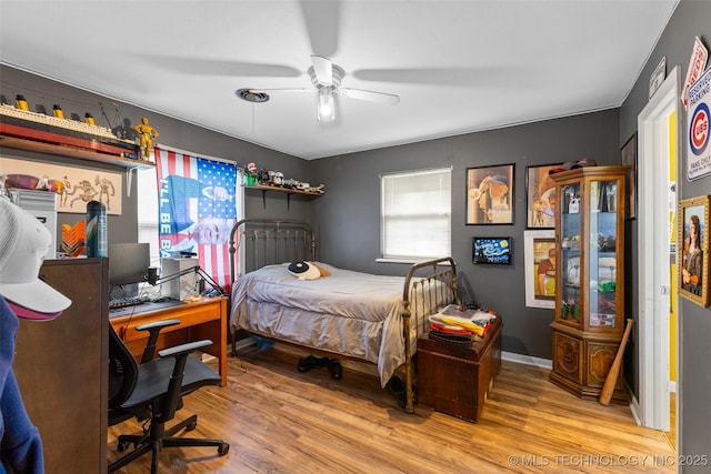 bedroom with baseboards, a ceiling fan, and wood finished floors