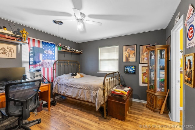 bedroom with light wood-style flooring, baseboards, and a ceiling fan