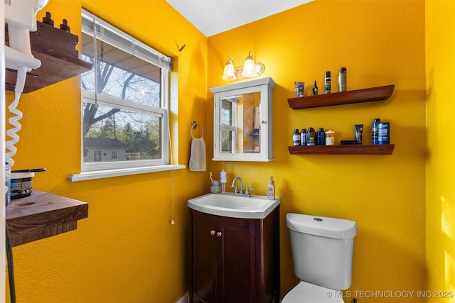 half bathroom with toilet and vanity