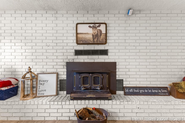 details featuring visible vents, a textured ceiling, and a large fireplace