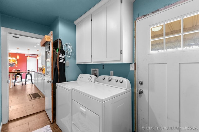 washroom featuring light tile patterned floors, separate washer and dryer, and cabinet space