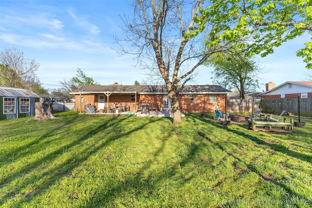 back of house featuring a patio, a yard, and a fenced backyard