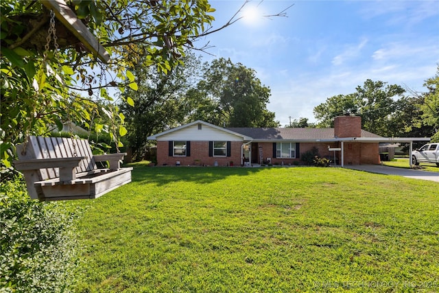 221 S Harvey, Ada, OK 74820 - view of front facade with brick siding, driveway, a carport, a front lawn, and a chimney