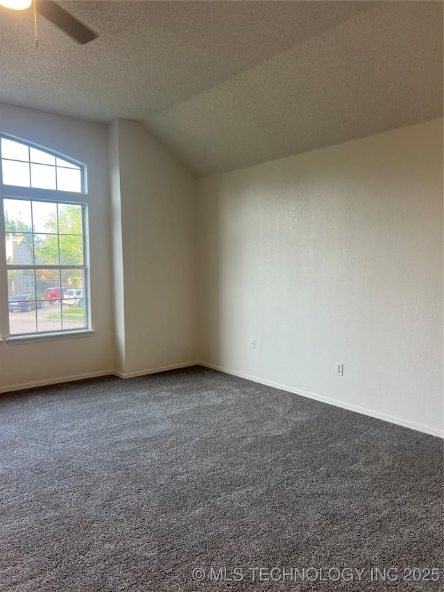additional living space with dark carpet, ceiling fan, baseboards, and a textured ceiling