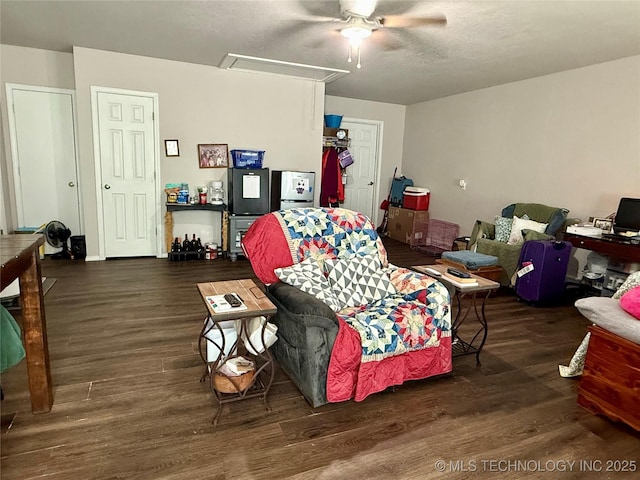 living area featuring attic access, a textured ceiling, wood finished floors, and ceiling fan