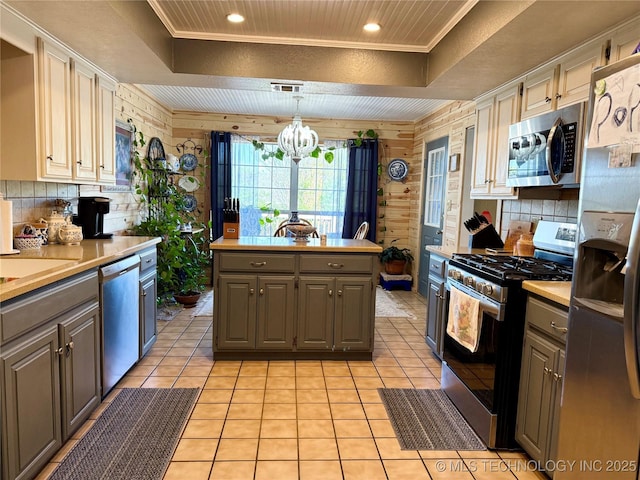 kitchen featuring light countertops, appliances with stainless steel finishes, gray cabinetry, and a raised ceiling