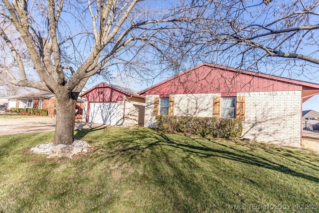 view of front facade featuring concrete driveway, a front yard, brick siding, and a garage