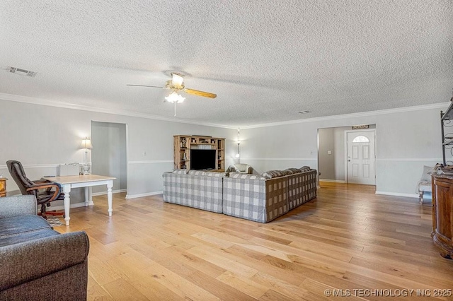 living room with ornamental molding, light wood-type flooring, and a ceiling fan