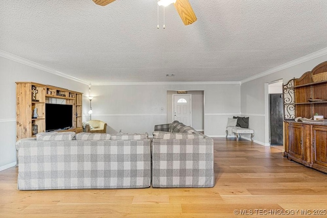 living room with crown molding, baseboards, wood finished floors, and a textured ceiling
