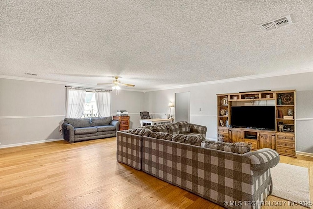 living room featuring visible vents, crown molding, a ceiling fan, and wood finished floors