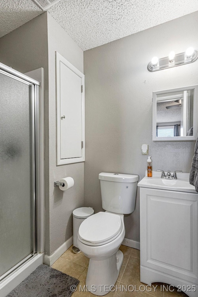 full bathroom with toilet, a stall shower, baseboards, and tile patterned flooring