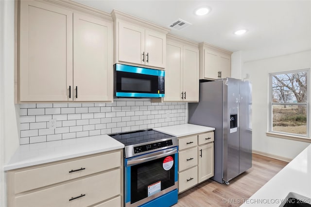 2002 W Driftwood Dr, Claremore, OK 74017 - kitchen featuring light countertops, light wood-style floors, visible vents, decorative backsplash, and appliances with stainless steel finishes