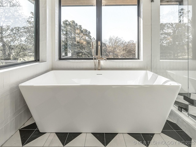 12415 Lakeview Rd, Sperry, OK 74073 - bathroom featuring a freestanding bath, tile patterned flooring, and tile walls