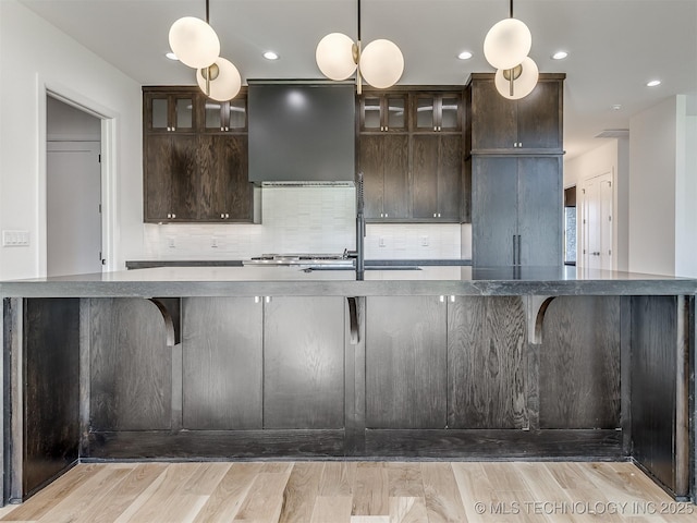 12415 Lakeview Rd, Sperry, OK 74073 - kitchen with tasteful backsplash, light wood-style floors, wall chimney exhaust hood, and dark brown cabinets