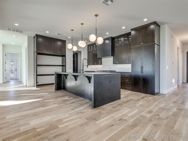 12415 Lakeview Rd, Sperry, OK 74073 - kitchen with light wood-type flooring, wall chimney range hood, and visible vents