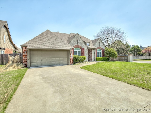 french provincial home with an attached garage, fence, concrete driveway, brick siding, and a front lawn