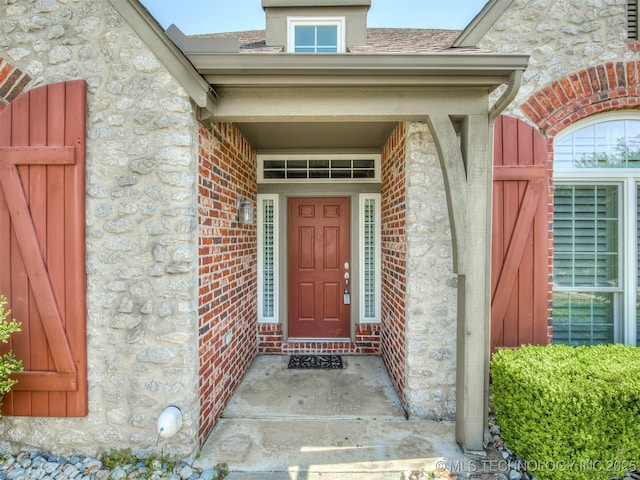 doorway to property with brick siding and stone siding