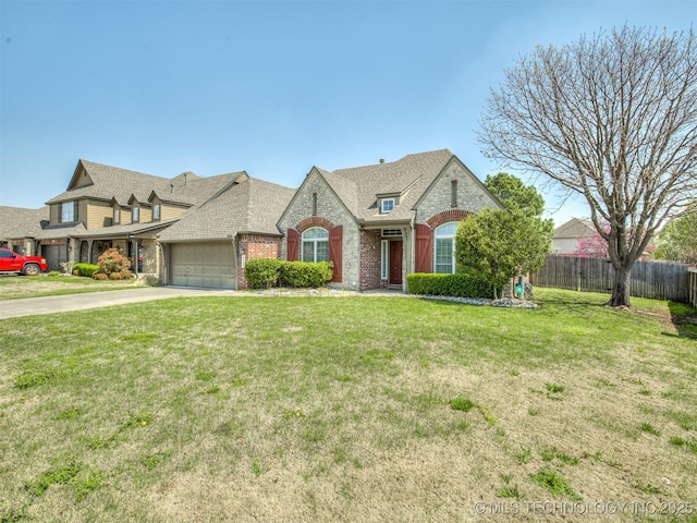view of front of home with a front lawn, an attached garage, brick siding, fence, and a shingled roof