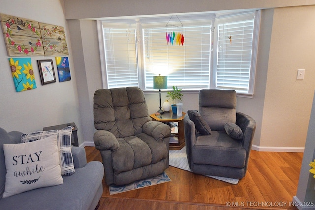 sitting room with plenty of natural light, baseboards, and wood finished floors