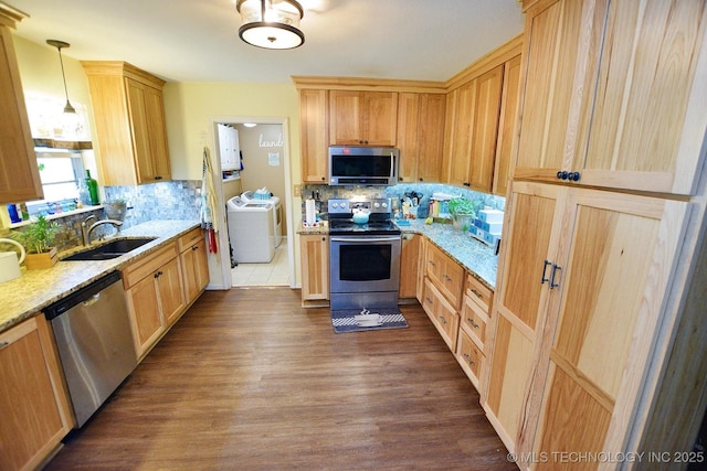 kitchen with light brown cabinetry, backsplash, a sink, appliances with stainless steel finishes, and washer / clothes dryer
