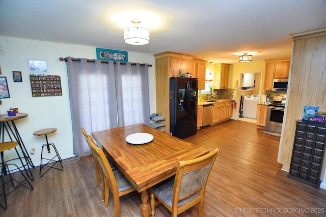 dining area with washer / dryer and wood finished floors