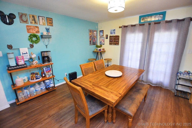 dining area with baseboards and wood finished floors