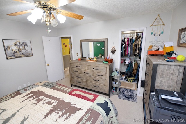 bedroom featuring light colored carpet, a textured ceiling, a closet, and ceiling fan