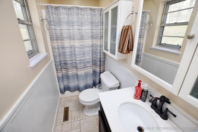 bathroom with a wainscoted wall, visible vents, toilet, vanity, and a shower with shower curtain