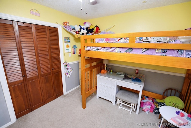 carpeted bedroom featuring ceiling fan, baseboards, a textured ceiling, and a closet