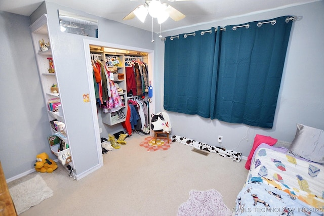 carpeted bedroom featuring a closet, a ceiling fan, and baseboards