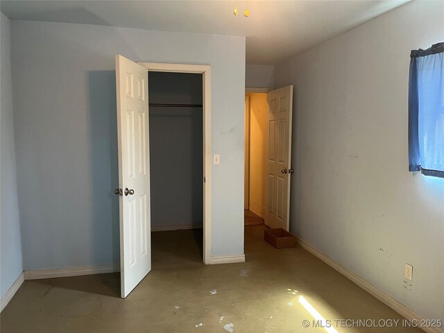216 N Bk 1600 Rd, Stigler, OK 74462 - unfurnished bedroom featuring concrete floors, baseboards, and a closet