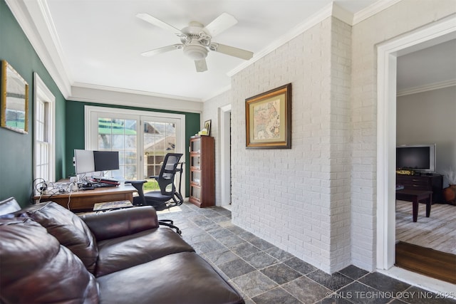 living area with ornamental molding, a ceiling fan, stone tile floors, and brick wall