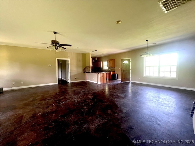 220 Willow Ln, Hartshorne, OK 74547 - unfurnished living room with concrete floors, baseboards, ceiling fan, and a chandelier