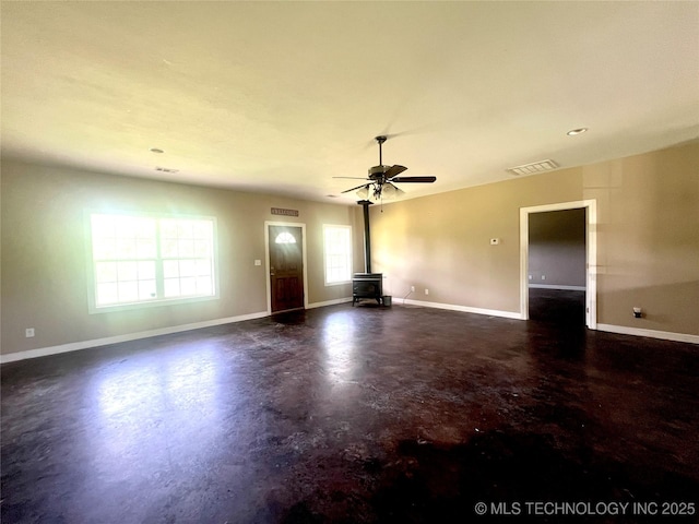 220 Willow Ln, Hartshorne, OK 74547 - unfurnished living room with a wood stove, finished concrete flooring, baseboards, and ceiling fan
