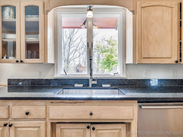 614 Oak Ridge Dr, Sand Springs, OK 74063 - kitchen with light brown cabinetry, stainless steel dishwasher, a sink, dark countertops, and glass insert cabinets