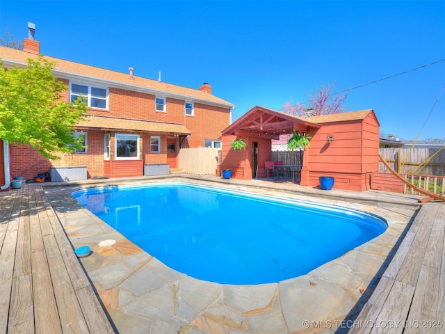 614 Oak Ridge Dr, Sand Springs, OK 74063 - view of swimming pool with a wooden deck, a fenced backyard, and an outbuilding