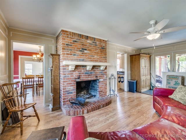 614 Oak Ridge Dr, Sand Springs, OK 74063 - living area featuring light wood-type flooring, a ceiling fan, crown molding, a fireplace, and a decorative wall