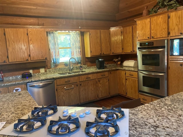 17735 S 75th St E, Warner, OK 74469 - kitchen with brown cabinetry, appliances with stainless steel finishes, light stone countertops, and a sink