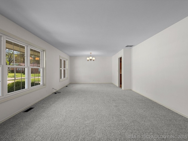 spare room with visible vents, baseboards, a notable chandelier, and carpet floors