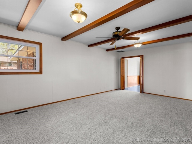 spare room with visible vents, ceiling fan, beam ceiling, and carpet