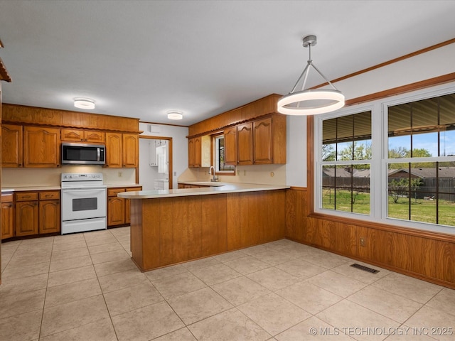 kitchen with stainless steel microwave, visible vents, brown cabinetry, and white electric range oven