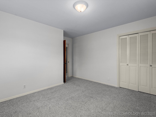 unfurnished bedroom with a closet, baseboards, and carpet floors