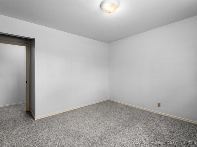 carpeted spare room featuring baseboards