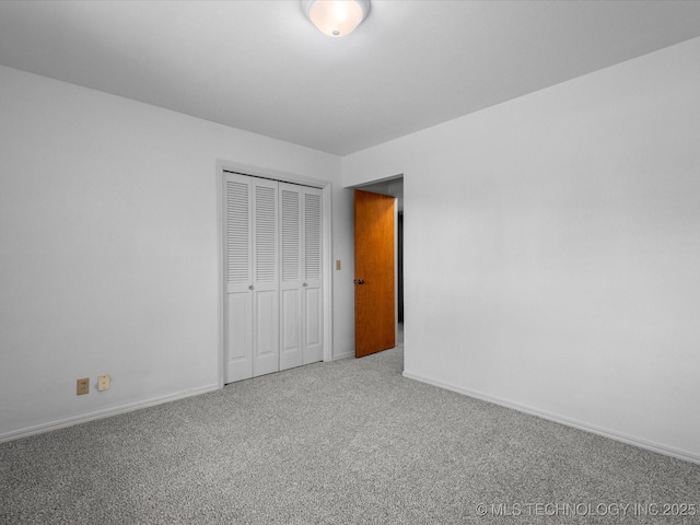 unfurnished bedroom with a closet, baseboards, and carpet