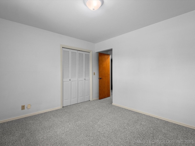 unfurnished bedroom with a closet, carpet flooring, and baseboards