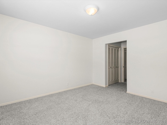 spare room with carpet and baseboards